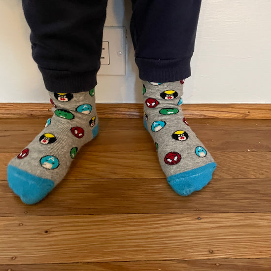 Kids socks on child's feet with colorful superheroes. Spider Man, Captain America, Iron Man, The Hulk. Made from sustainable bamboo.