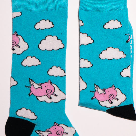 One of our most popular designs. The perfect shade of blue meets our lovable pink pigs - who said these guys could not fly! Soft. Strong. Sustainable. Comfortable.  Pigs! On Socks. We know! Madness.  Available in US Men’s 4-8 and 8-12